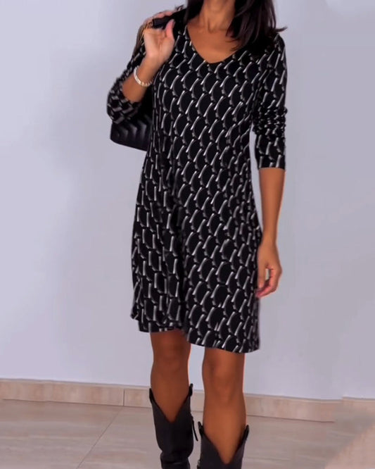 Diamond print v-hals jurk in de kleur Zwart voor dames in stijl ideaal voor de herfst.